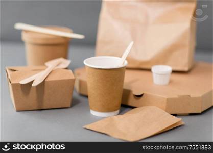 package, recycling and eating concept - disposable paper containers for takeaway food on table. disposable paper containers for takeaway food