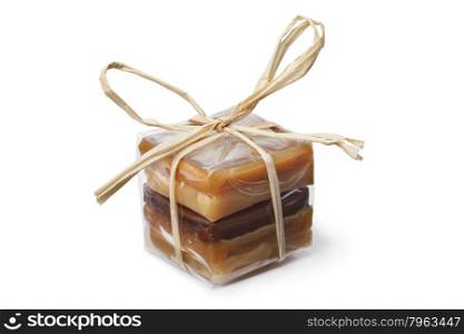 Package with a variation of sweet caramel bonbons on white background