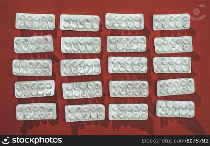 Packs of pills on red background