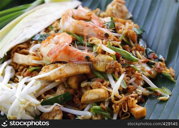 pad thai, stir-fried noodles with shrimp on banana leaf