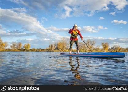 paddling stand up paddleboard on a lake in Colorado, fall scenery with a copy space