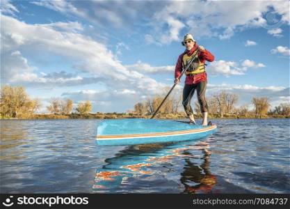 paddling stand up paddleboard on lake in Colorado, fall scenery