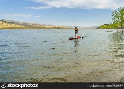 paddling stand up paddleboard on mountain lake in COlorado, summer scenery at Horsetooth Reservoir near Fort Collins