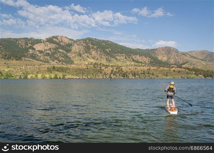paddling stand up paddleboard on mountain lake in northern Colorado, summer scenery at Horsetooth Reservoir near Fort Collins