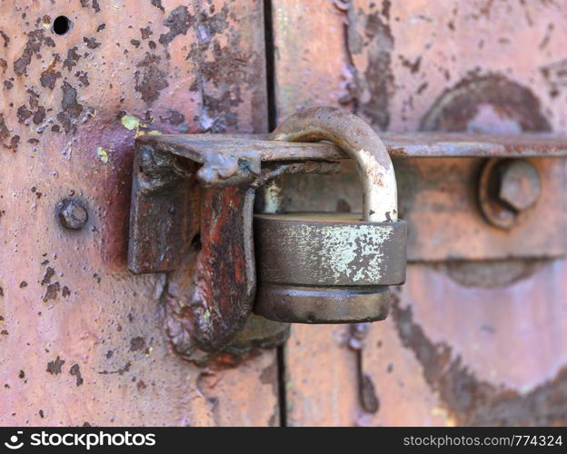 Padlock on the door. Rusty gate