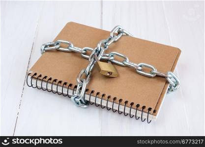 Padlock protects the notepad in a concept on protect the secret information