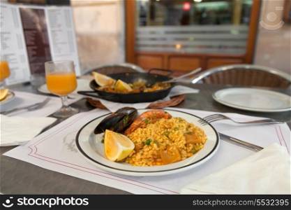 Paella on the plate in street cafe of Barcelona, Spain&#xA;