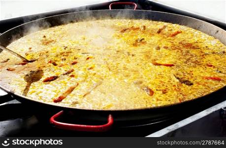 Paella rice typical from Valencia Spain cooking in big pan