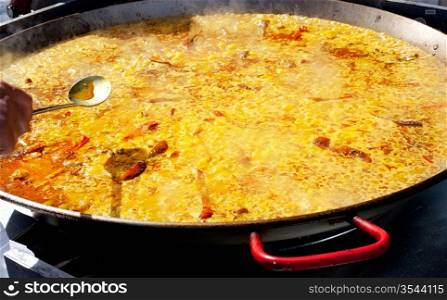 Paella rice typical from Valencia Spain cooking in big pan