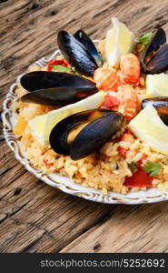 paella with seafood. vegetable paella with seafood from rice, mussels and lemon
