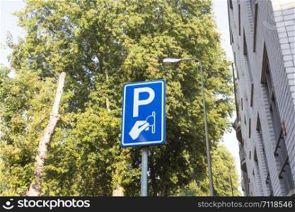Paid parking area sign, Paid services on a background of green trees in the city close-up. Paid parking area sign, Paid services on a background of green trees in the city