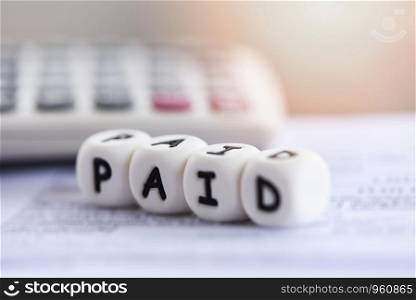 Paid words and calculator on invoice bill paper for time paid payment at office business finances