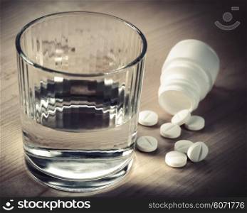 Painkiller. Abstract medical backgrounds with pills and glass of water over wooden desk