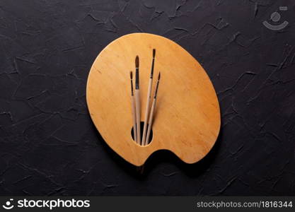 Paint brush andpalette at black abstract background texture. Paintbrush for oil painting still life. Art concept