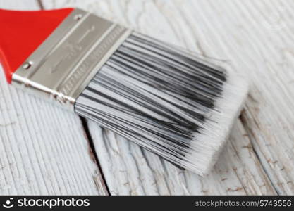 Paint brush on a white wooden board