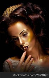 Paint. Fantasy. Glamor. Creative gold make-up, beauty woman face and fashion style