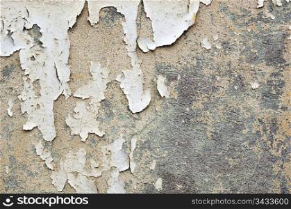 Paint peeling off a concrete wall forms grunge texture background