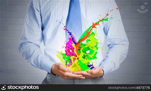 Paint splashes. Close up of businessman with paint splashes in hands