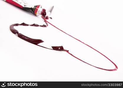 Paint tube and brush make a textured red heart over a white background.