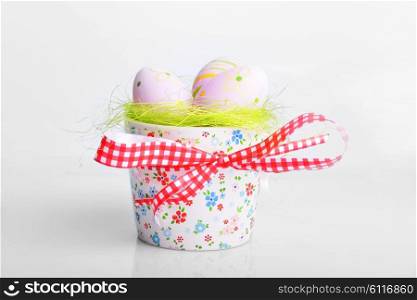 painted easter eggs on green in decorative bowl