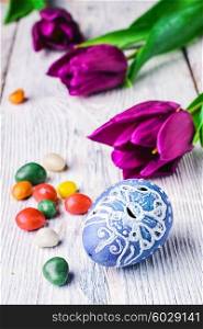 Painted eggs for the Easter holiday and the fresh bud of a tulip. Easter egg and tulip