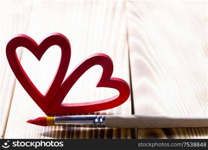 Painted heart and paint brush on wooden table, Valentines day gift concept. Painted heart and paint brush