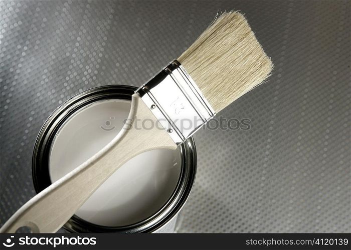Painter brush and white paint tin