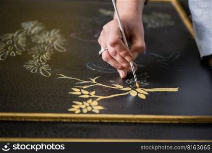 painter decorator draws a pattern of tree and leaves. artist decorator at work