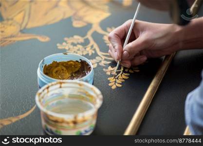 painter decorator draws a pattern of tree and leaves. artist decorator at work