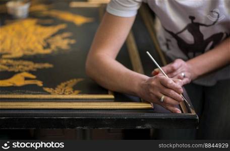 painter decorator draws pattern with a thin brush. artist decorator at work