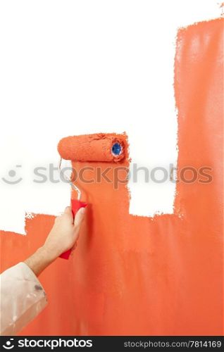 Painter painting over a white wall, making it bright organge with a paint roller