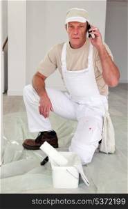 Painter stopping work to make call to supplier
