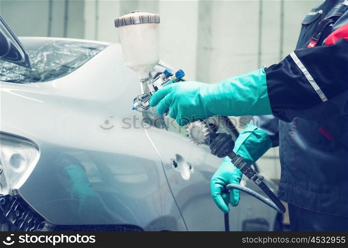painting a car. spray gun with paint for painting a car