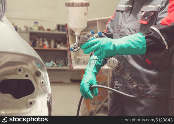 painting a car . spray gun with paint for painting a car