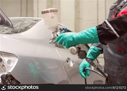 painting a car . spray gun with paint for painting a car