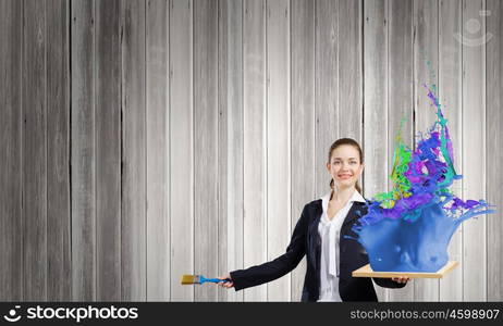 Painting art. Young businesswoman holding paint brush and wooden frame