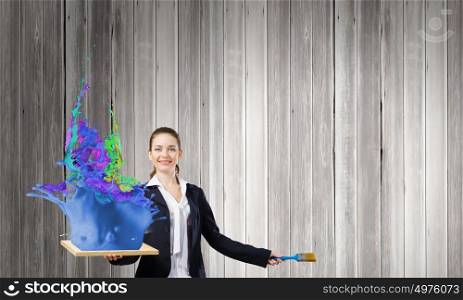 Painting art. Young businesswoman holding paint brush and wooden frame