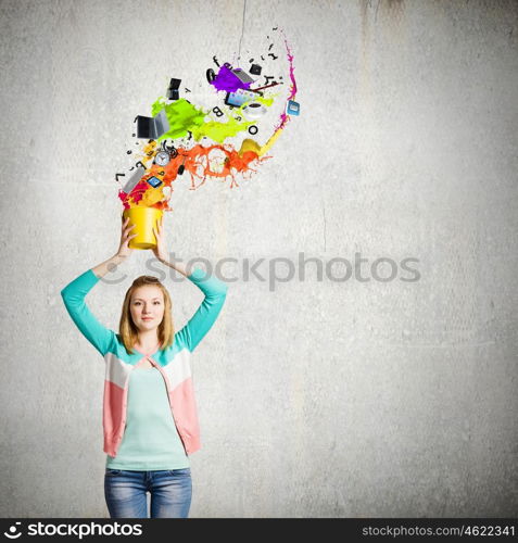 Painting concept. Young girl holding bucket with colorful splashes