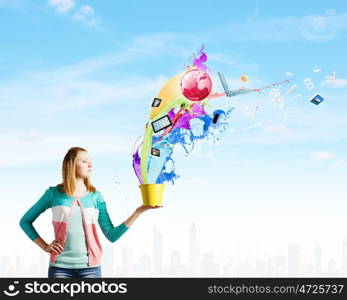 Painting concept. Young girl holding bucket with colorful splashes