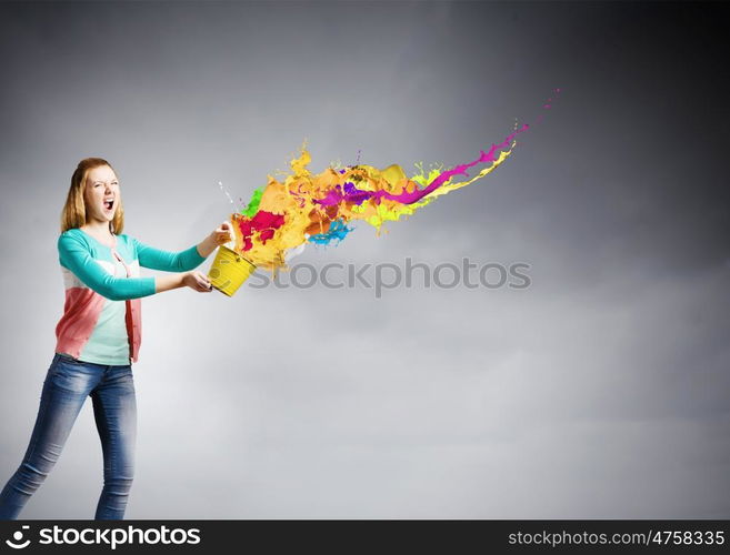 Painting concept. Young girl holding bucket with colorful splashes