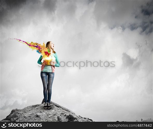 Painting concept. Young girl holding bucket with colorful splashes
