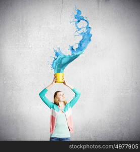 Painting concept. Young girl holding bucket with colorful splashes