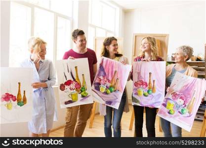 painting, education and people concept - group of artists or students holding still life pictures at art school studio. group of artists with pictures at art school