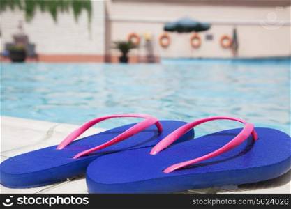 Pair of blue flip flops by the pool side