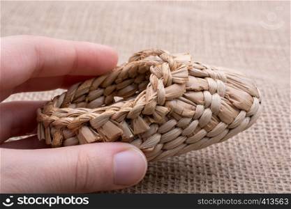 Pair of brown color straw shoes hand on a brown background