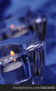 Pair of candles in a glass candlesticks, blue silk background