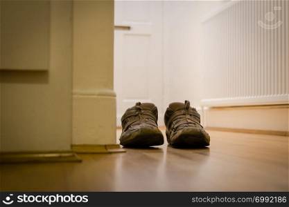 Pair of casual shoes in a domestic hallway
