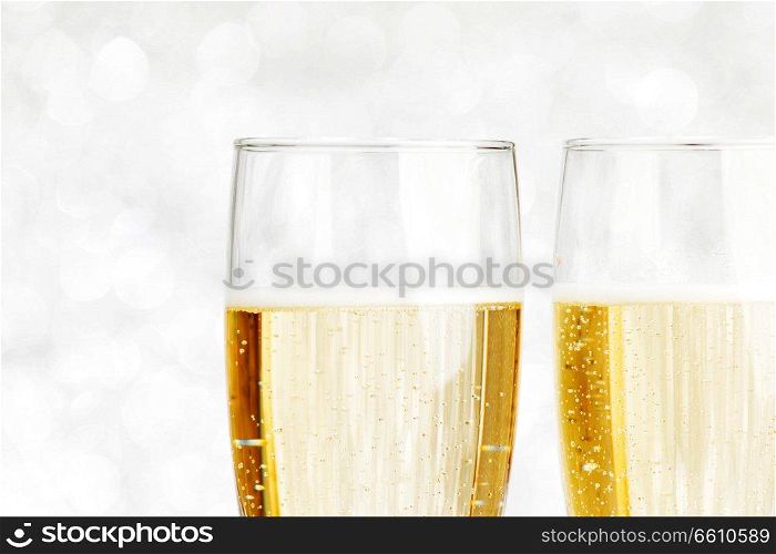 Pair of ch&agne flutes on shiny glitter background