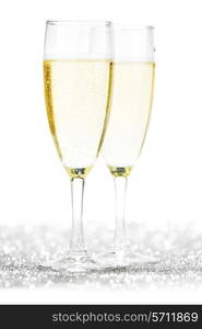 Pair of champagne flutes on shiny glitter background