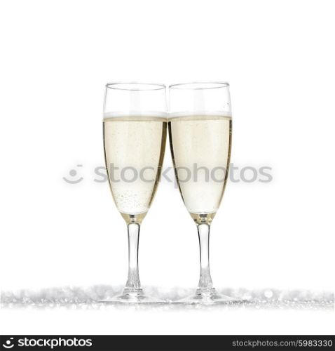 Pair of champagne flutes on shiny glitter background
